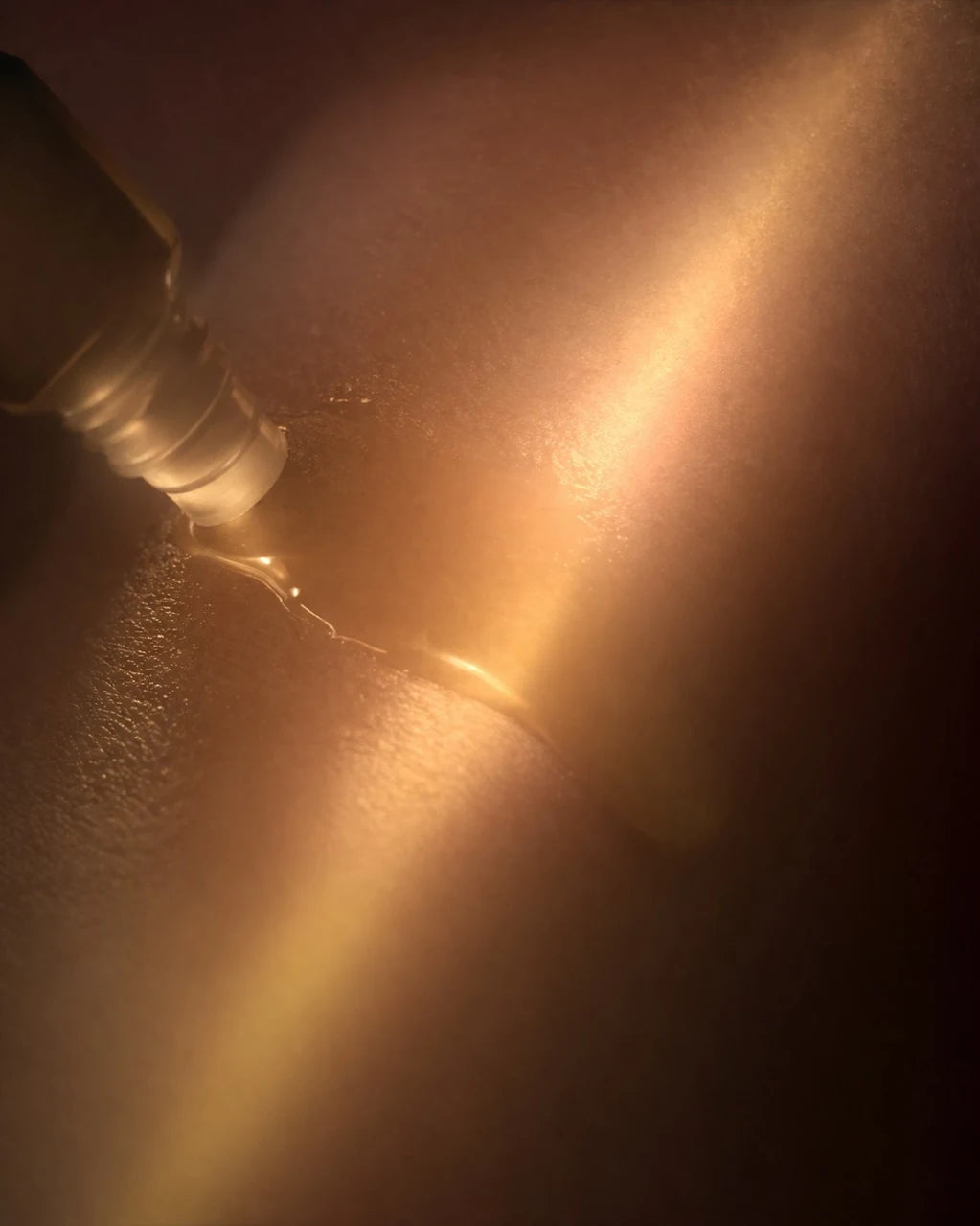 A roller applicator meets textured skin in warm light.